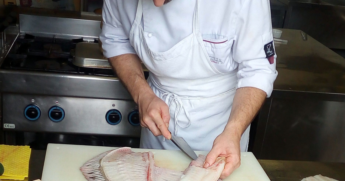 filettatura di un pesce rombo con un coltello giapponese deba in stile tradizionale